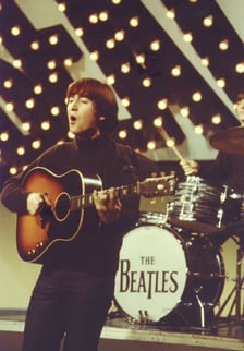 John Lennon chantant et jouant de la guitare