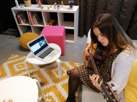 Femme apprenant la guitare en ligne 