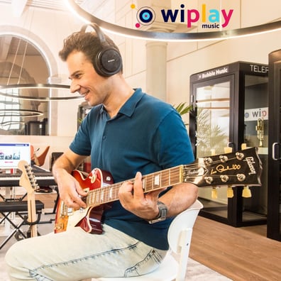 Jeune homme apprenant la guitare chez Wiplay Music