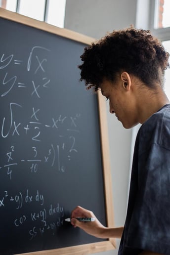 Etudiant  écrivant des calculs mathématiques sur un tableau