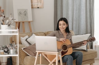Une femme apprend la guitare en ligne