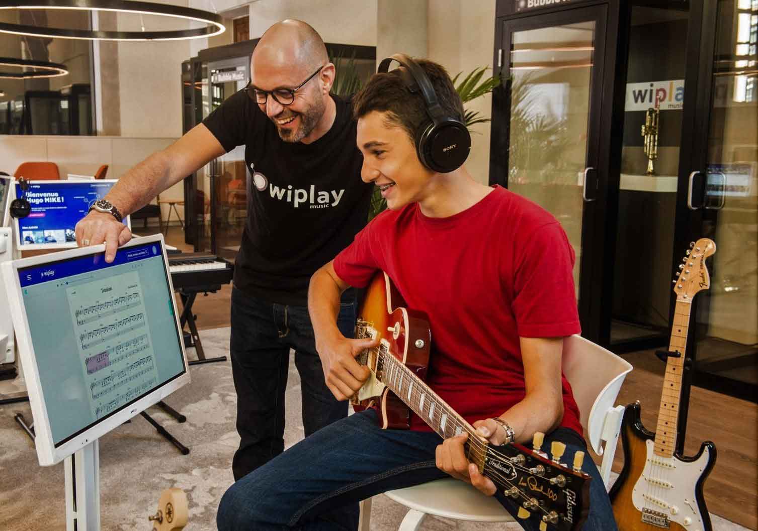 Cours-de-guitare-avec-un-prof-et-un-élève-débutant.PH