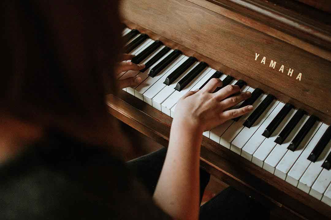 Femme qui joue du piano avec une bonne posture.