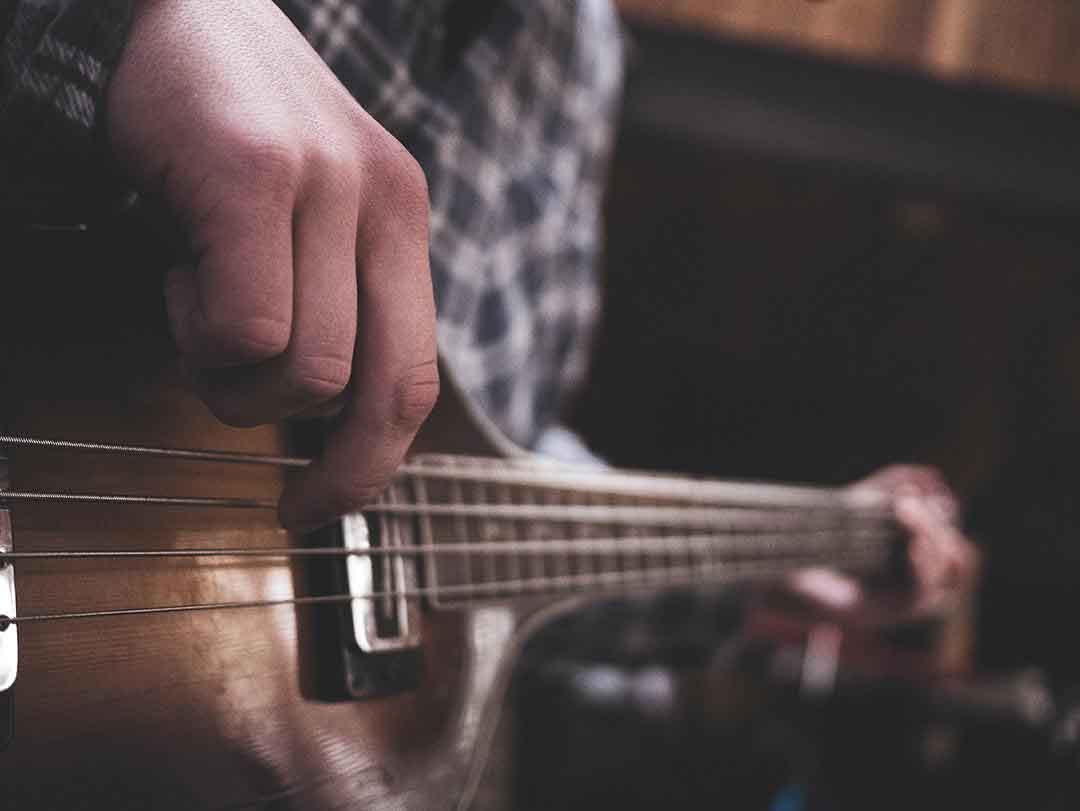 Focus-sur-une-main-qui-fait-du-finger-picking-sur-une-basse.PH