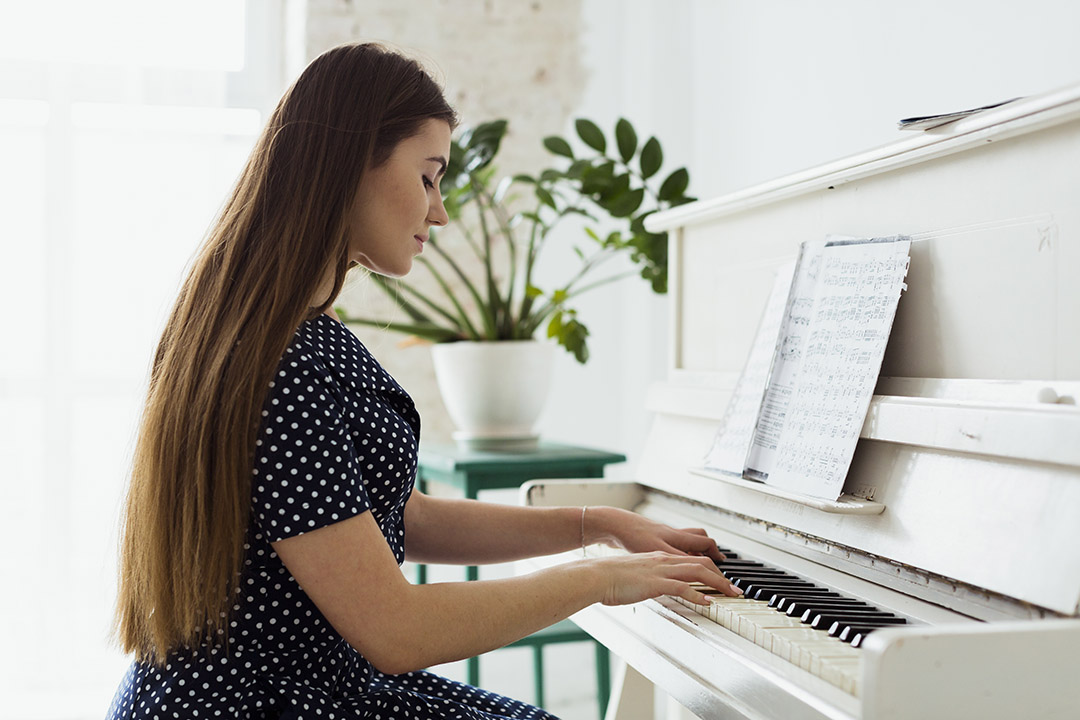 Femme qui joue du piano devant une partition